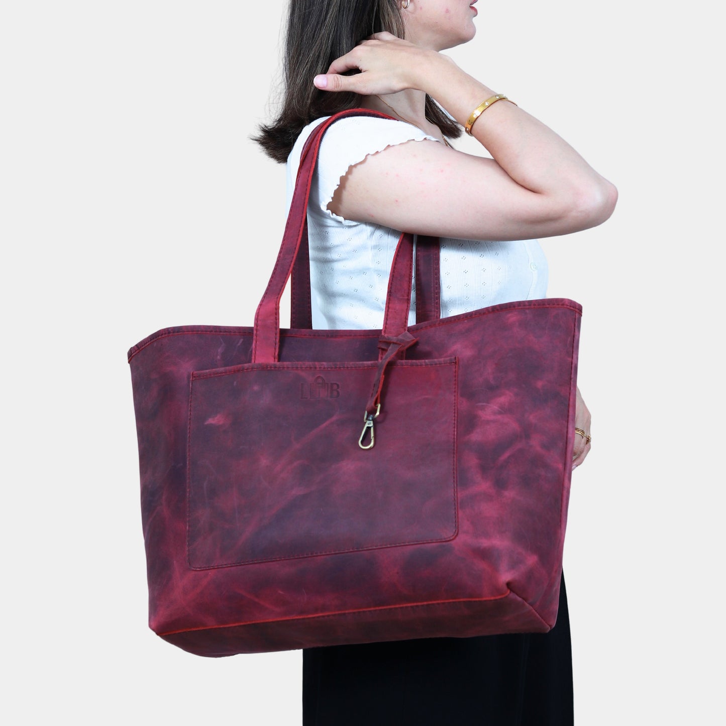 Women in white shirt slinging Large Work Leather Tote at her shoulder
