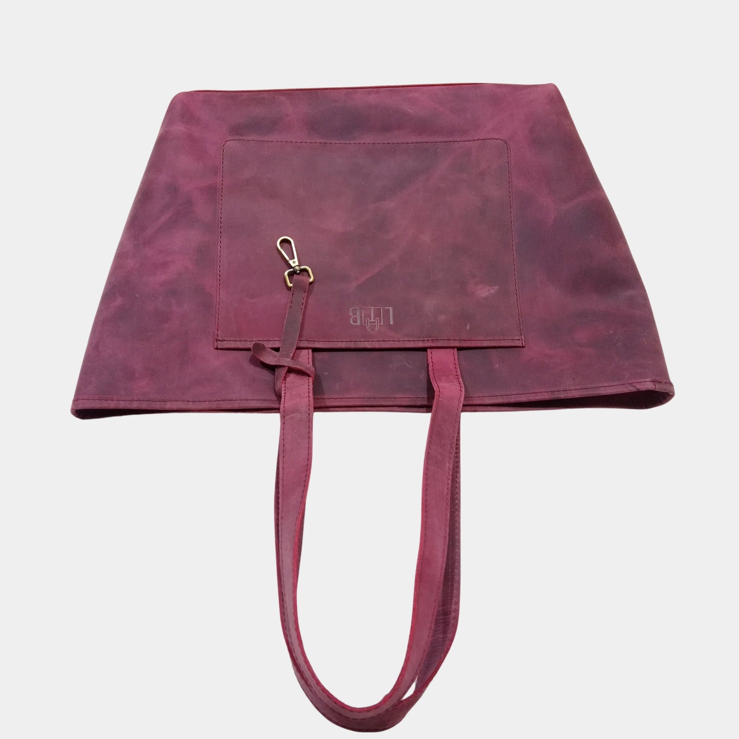 Large office Leather Tote laying on table showing profile of bag featuring vintage brass accessory strap