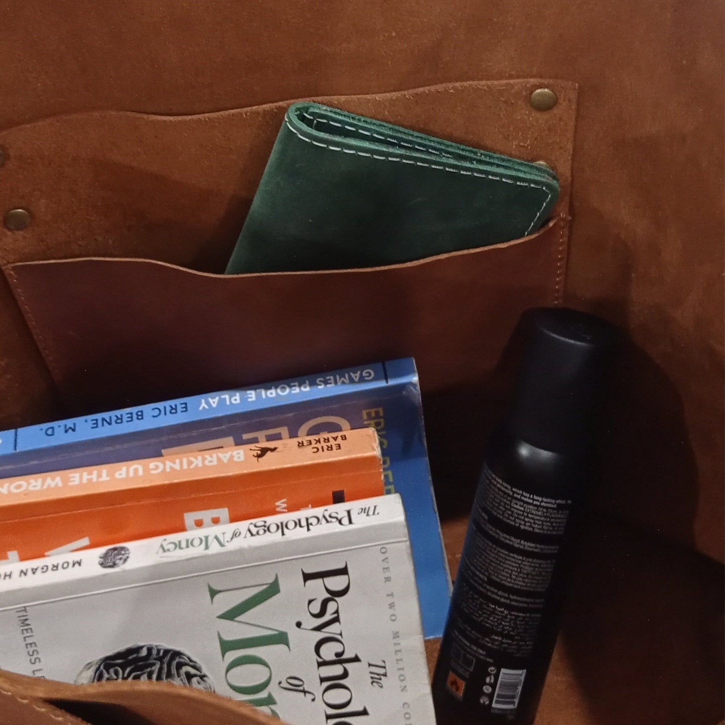 Inner View of Large Brown Leather Tote books spray bottle and green wallet in Hanging pocket