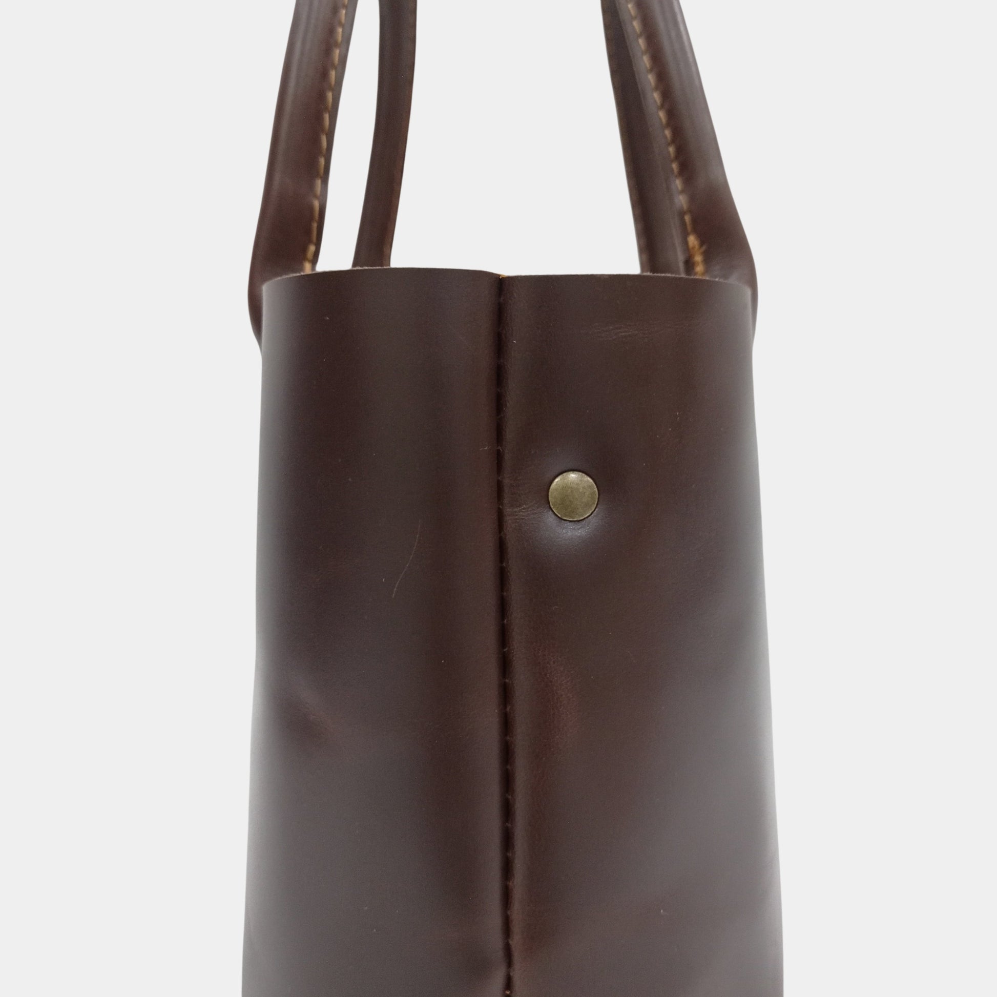 Side view of Sienna small handy leather tote featuring classic brass rivets