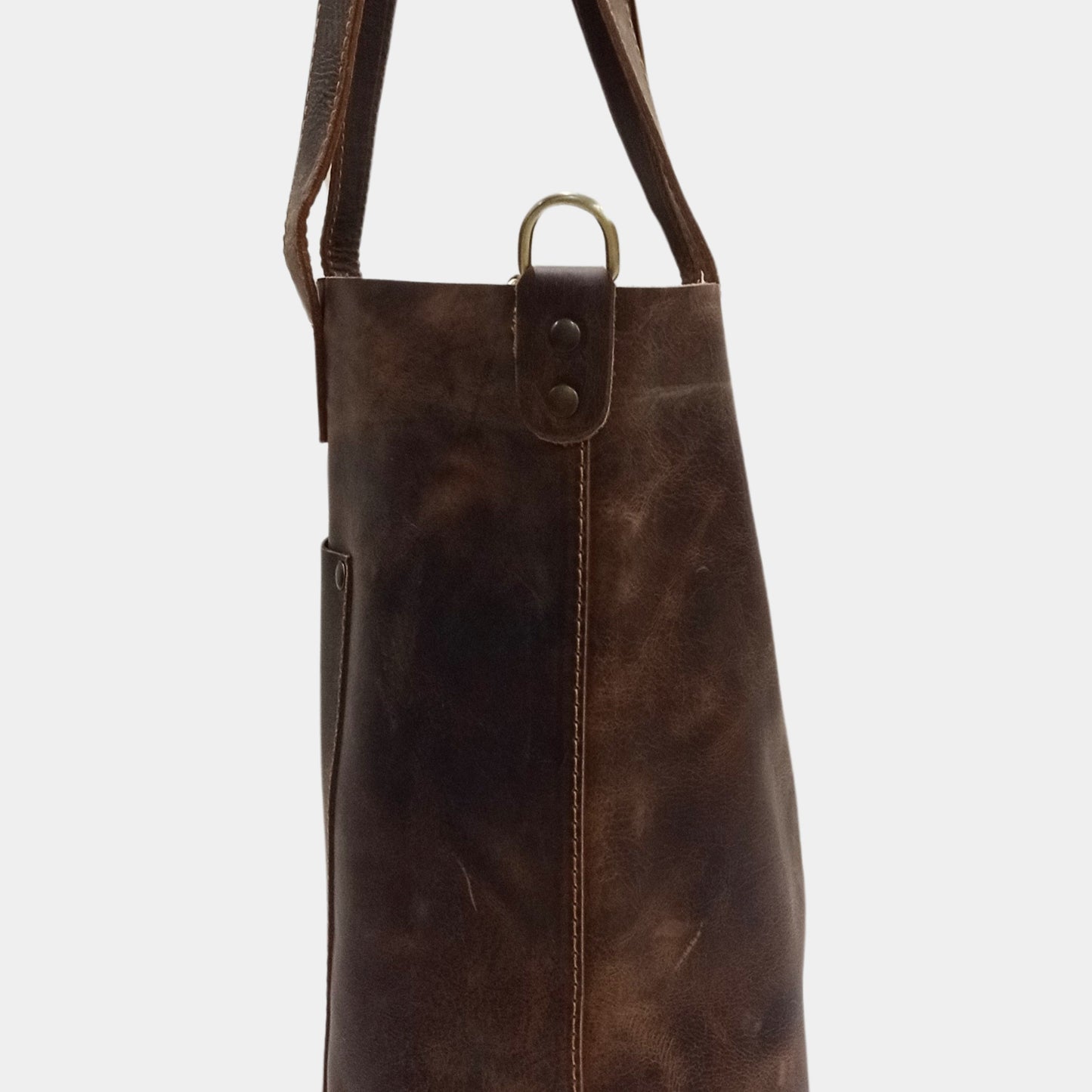 Close side view of brown large leather tote bag showcasing the fine stitching and brass hardware