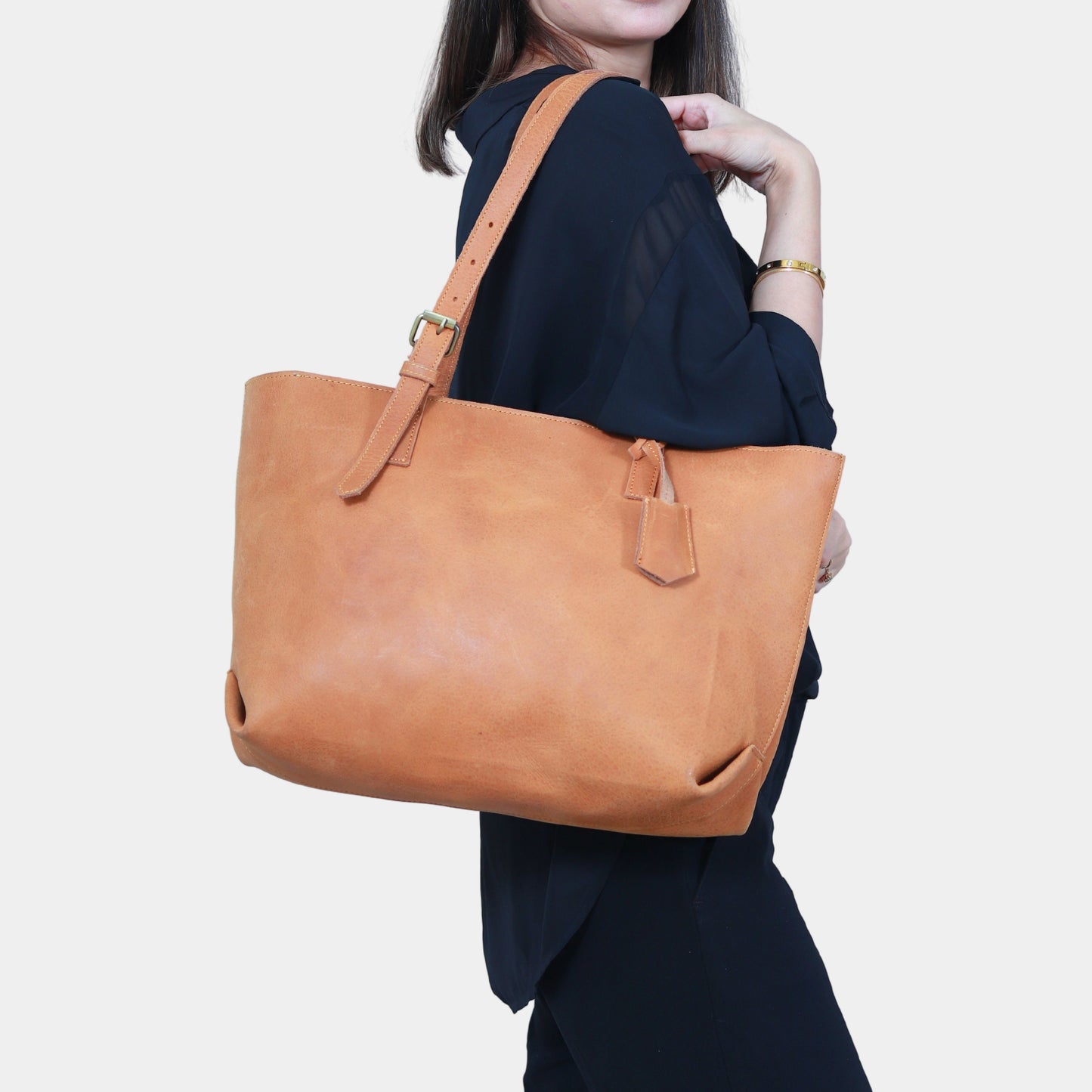 Teenage girl hanging brown work leather tote elegantly at her shoulder 