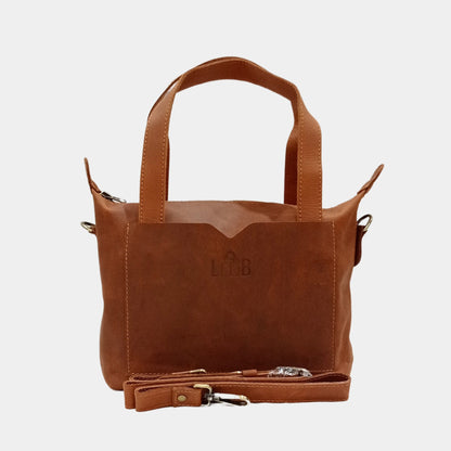 Elegant small brown leather tote by Australia with removable straps placed in front of bag