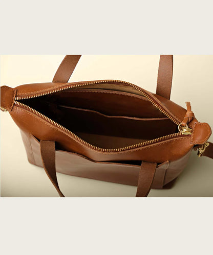 Top of stylish small leather tote bag showing sturdy zippers and interior hanging pockets