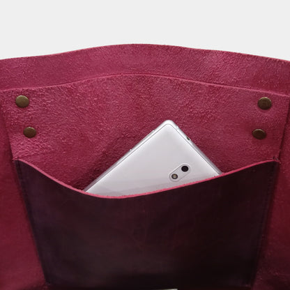 Interior of work leather tote showing white mobile in hanging pocket inside bag