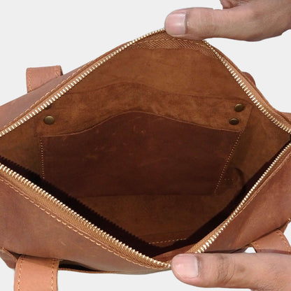 Close inside view of small brown tote bag showcasing soft unlined interior and hanging pocket inside