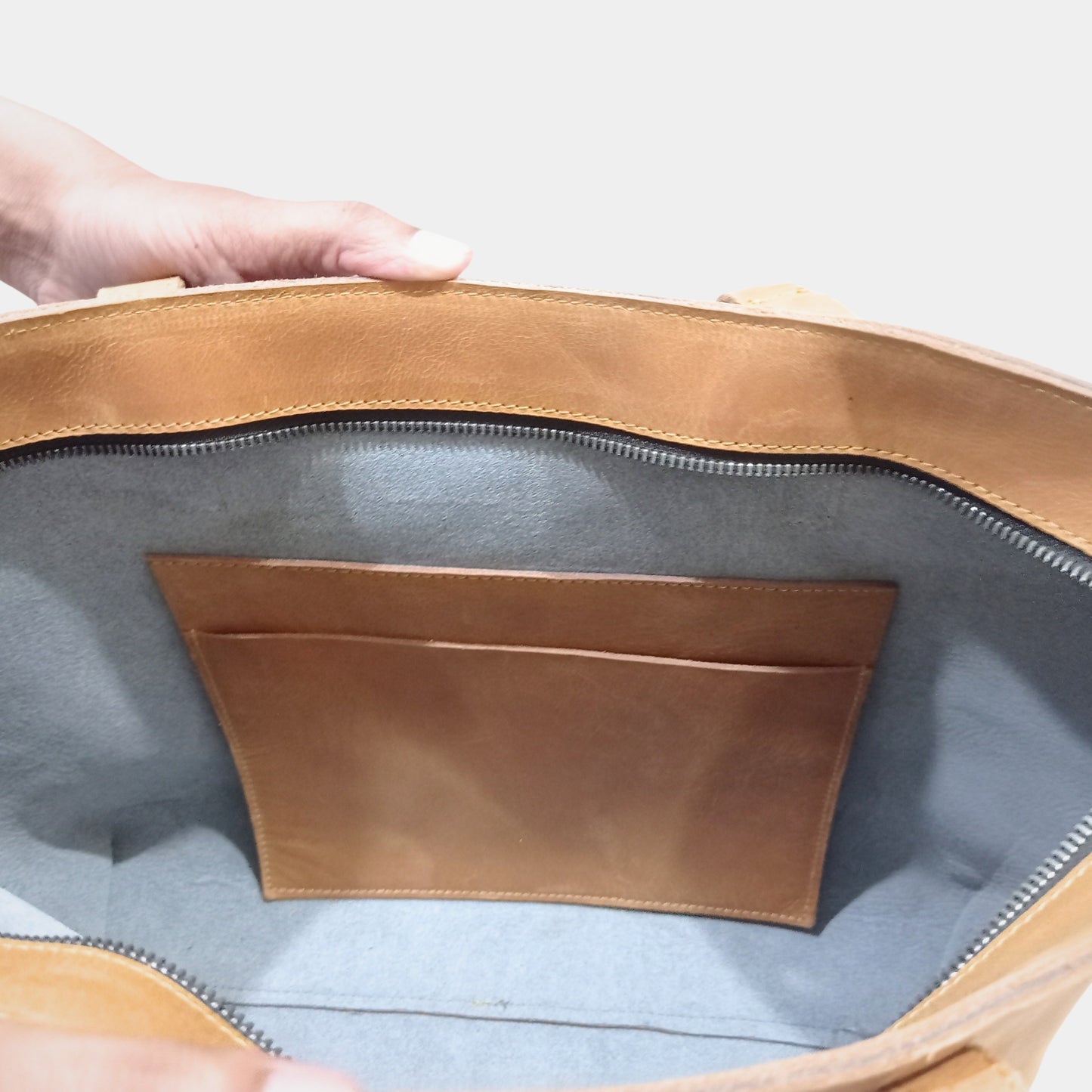 Interior of elegant work leather tote showing sturdy Top YKK Zippers internal pocket and unlined interior