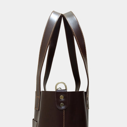 Close side view of Ruby Brown Leather Tote showing dual lined handles and brass hardware