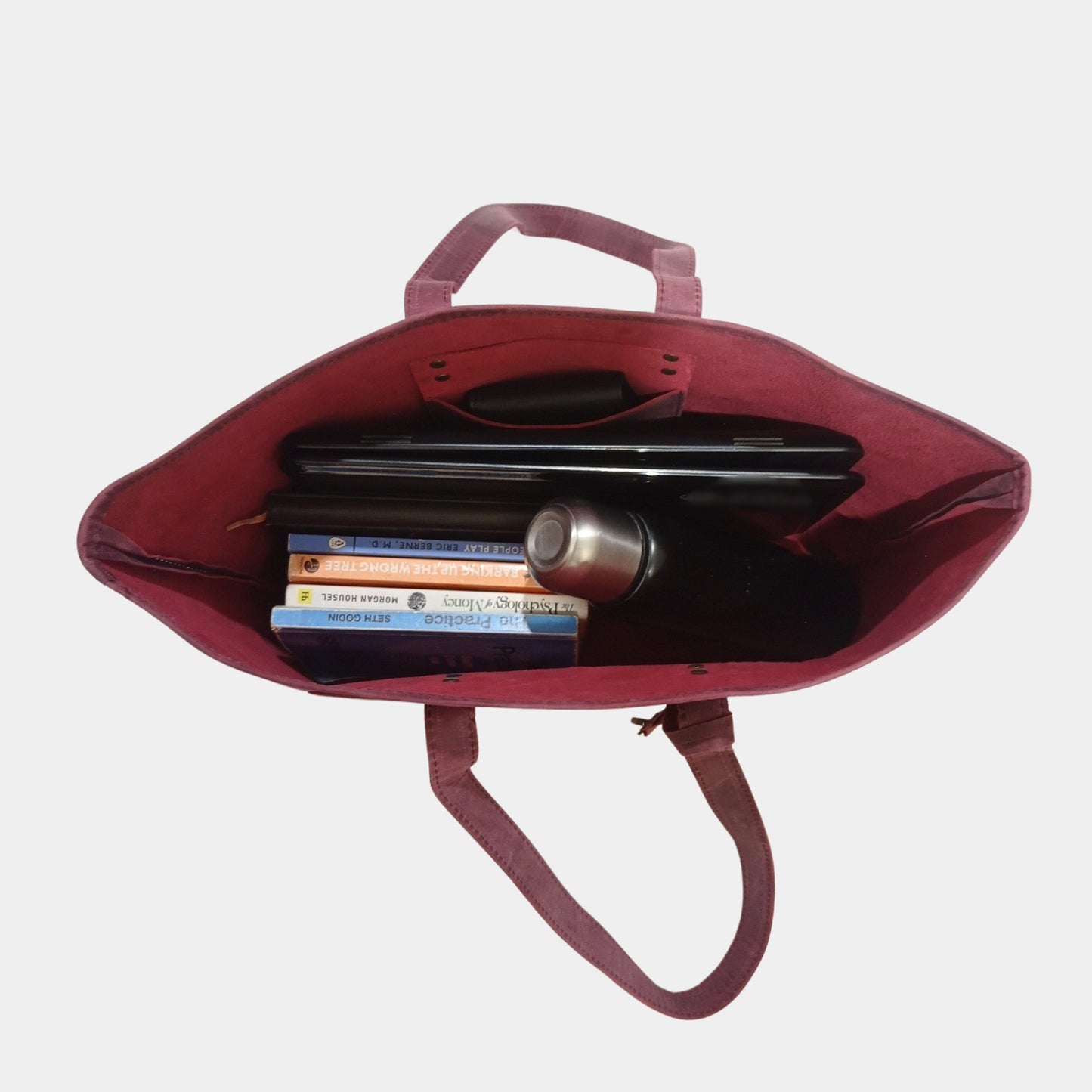 Trendy Work Leather Tote holding water bottle, books, and laptop while wallet is hanging pocket 