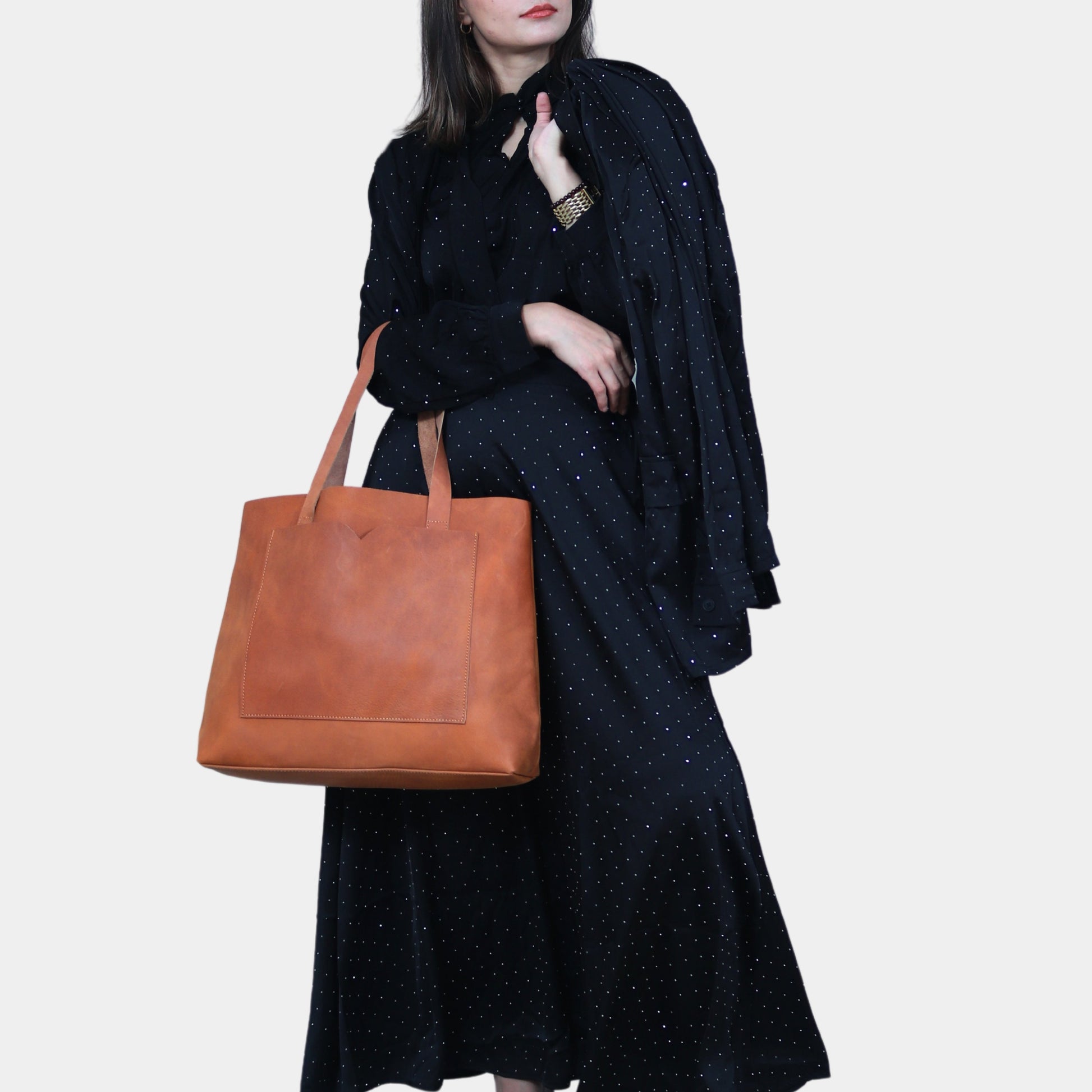 Teenage girl in black party dress with golden dots posing with Matilda Leather Tote Bag in her arm