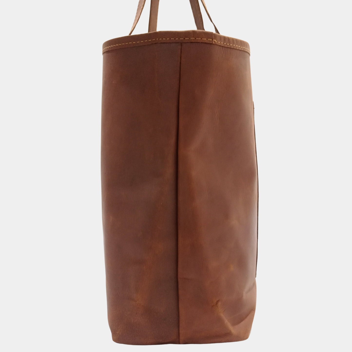 Side of elegant brown leather Mila Tote showing fine stitching and at side