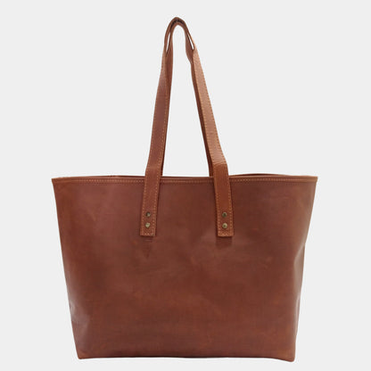 The backside of large brown work tote with large dual lined handles and brass rivets 