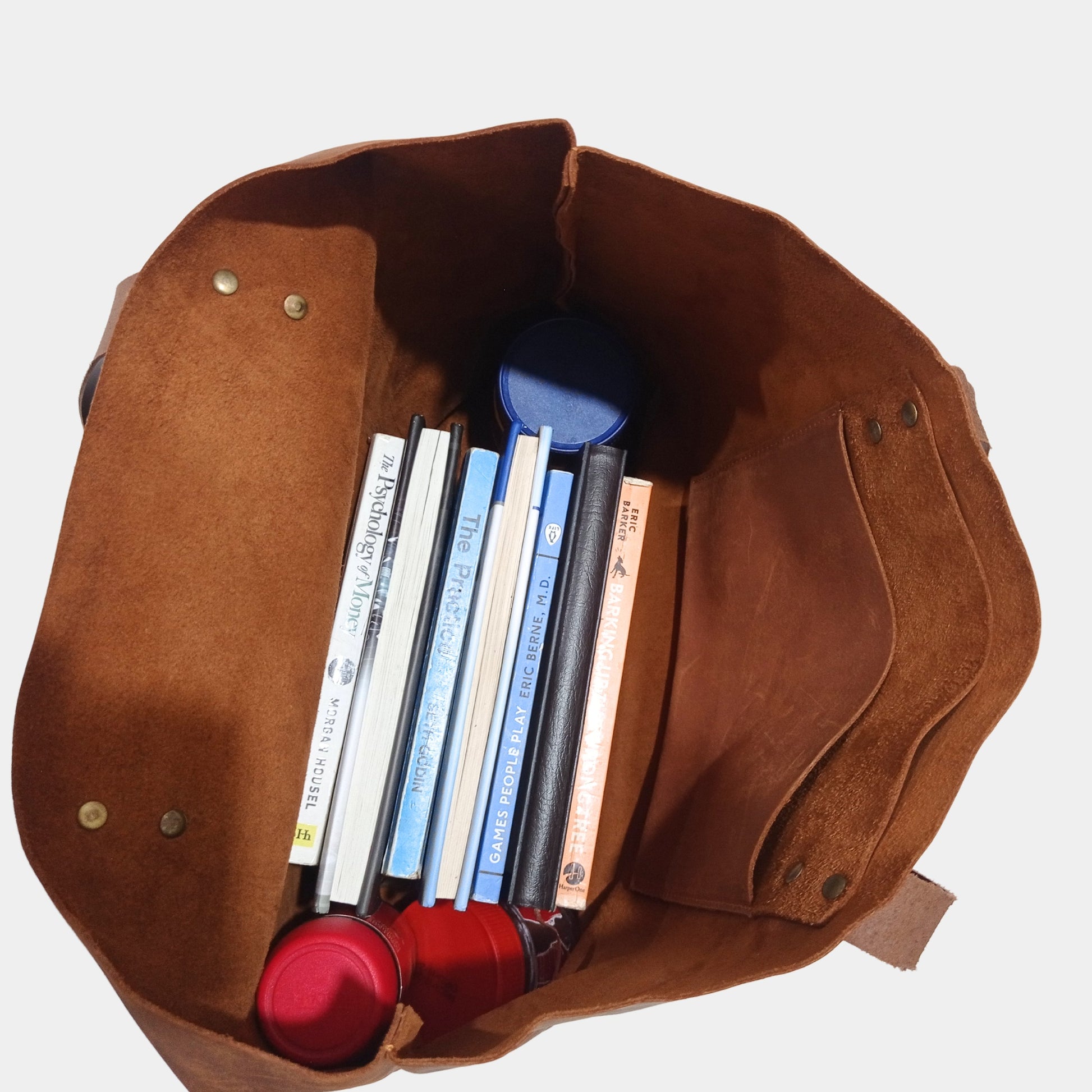 Unlined Rugged interior of Large Brown leather holding notebooks books and bottles inside with ease