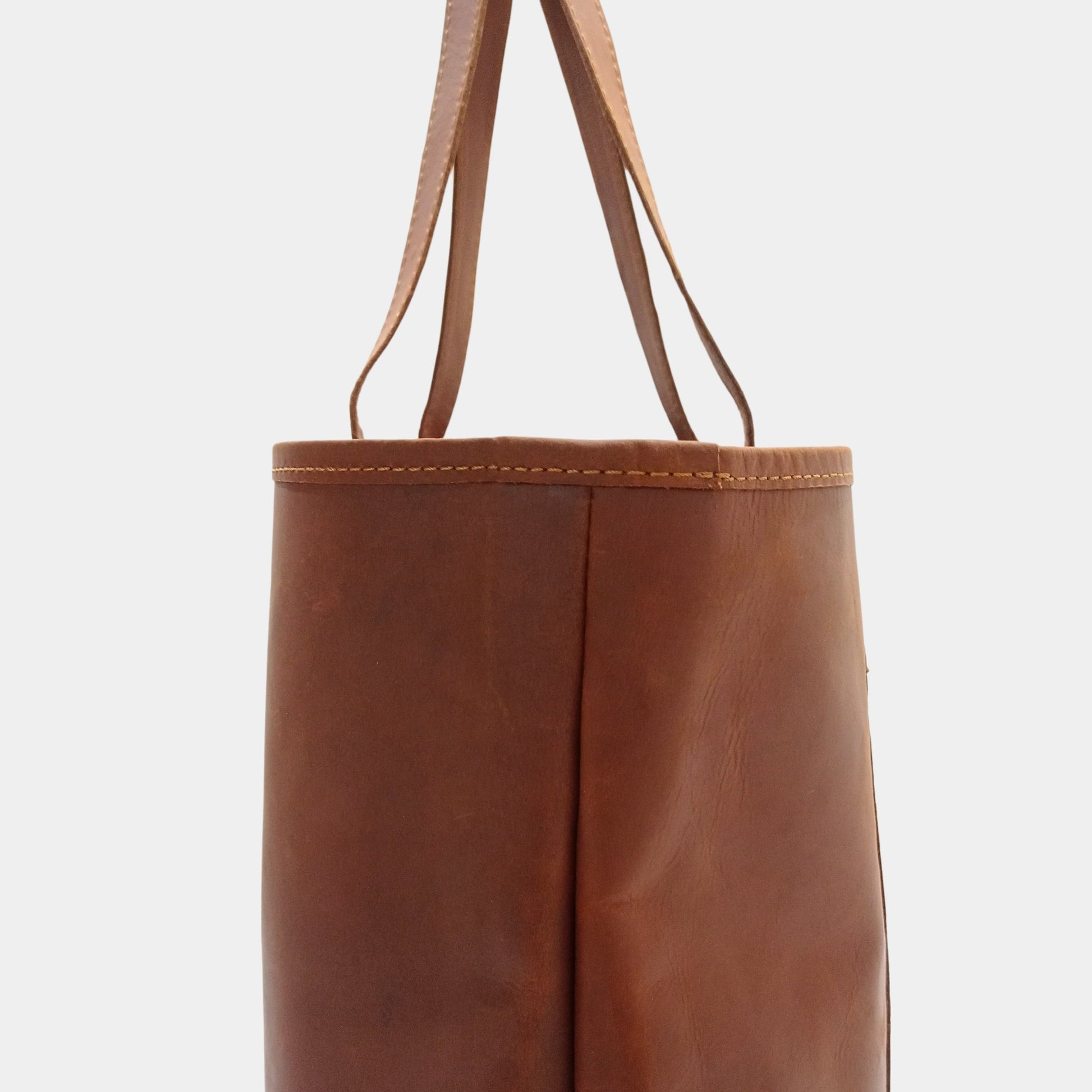 Close side view of Brown Mila leather tote bag focusing fine hand stitching