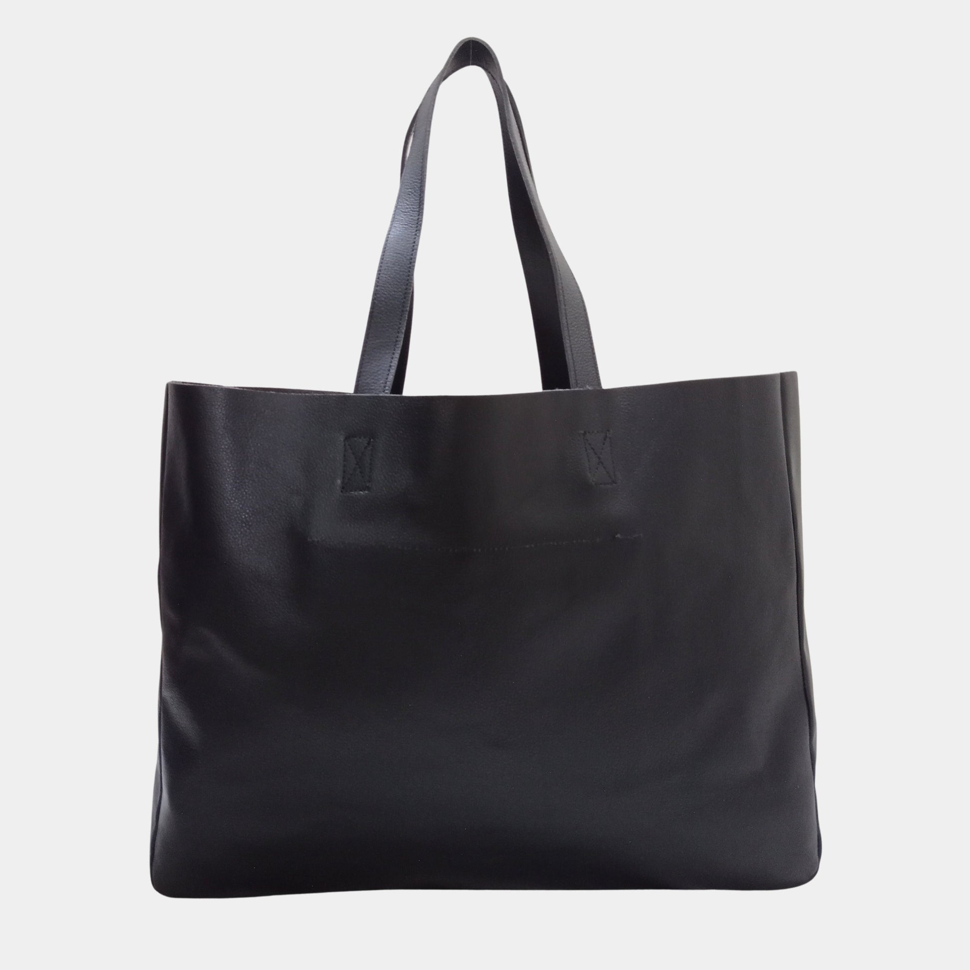 The backside of large black pebbled premium leather tote bag with sturdy long handles